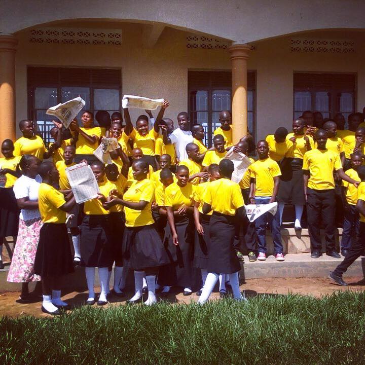 Secondary school students celebrate their exam success outside their school built by the charity Love iN aCTION