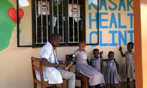 Health clinic set up by charity Love In Action - nurse taking care of children outside clinic